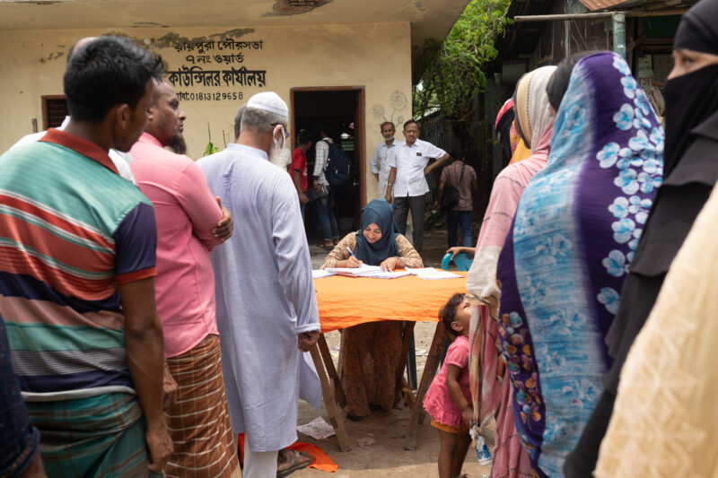 People wait in line to get screened