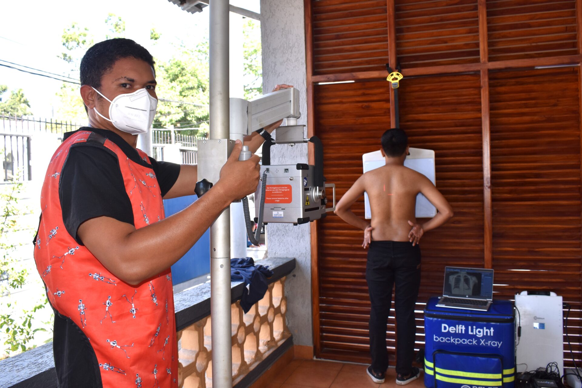 A radiographer positioning an elderly patient for a chest X-ray with the Delft Light system in Timor-Leste.