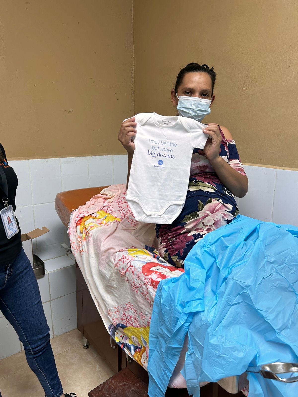 A pregnant women in Honduras is holding the BabyChecker onesie