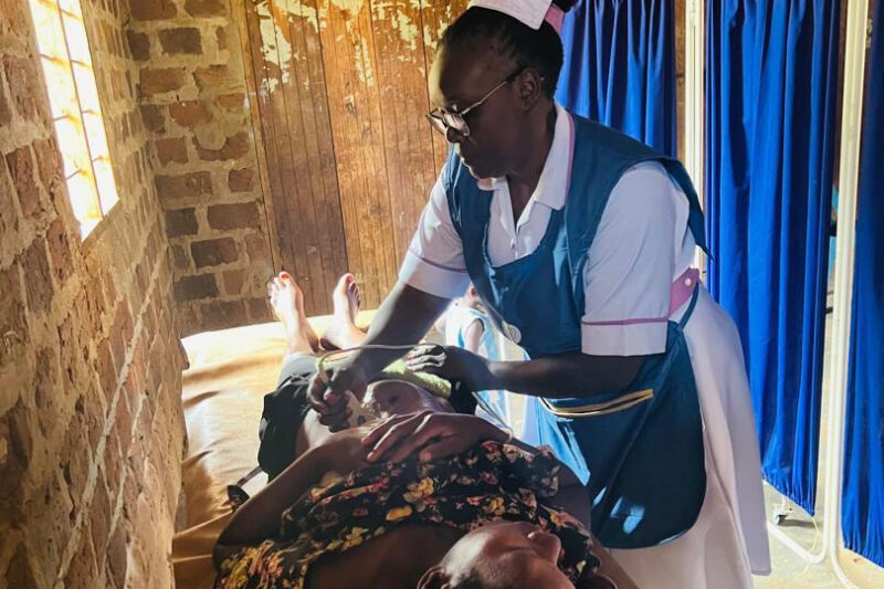 A health worker using BabyChecker to perform an obstetric ultrasound scan on a pregnant woman at a Viya Health facility in Uganda.