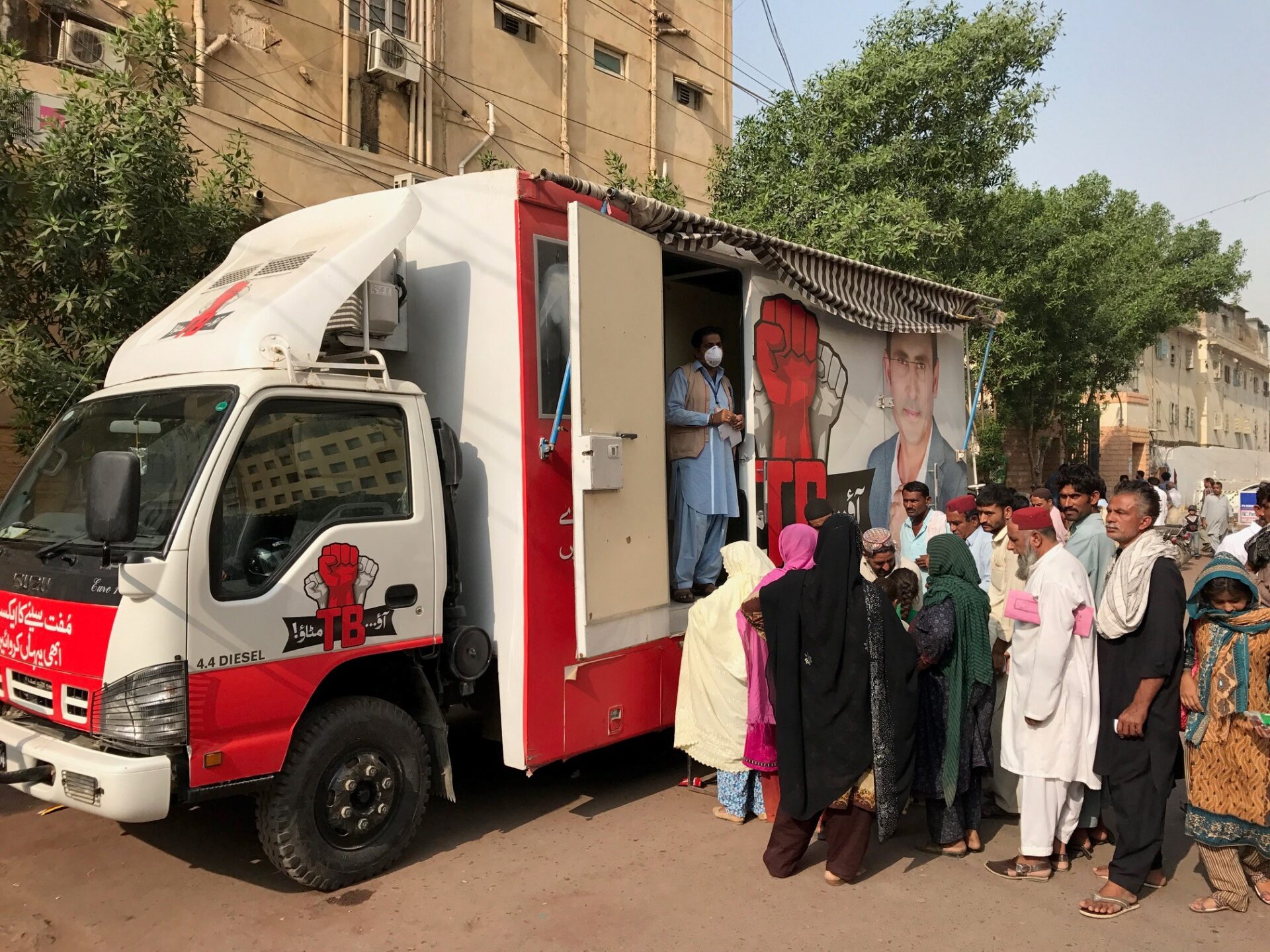 People are waiting in line in front of the mobile clinics to have the chest X-ray scan in Pakistan
