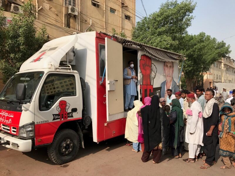 People are waiting in line in front of the mobile clinics to have the chest X-ray scan in Pakistan