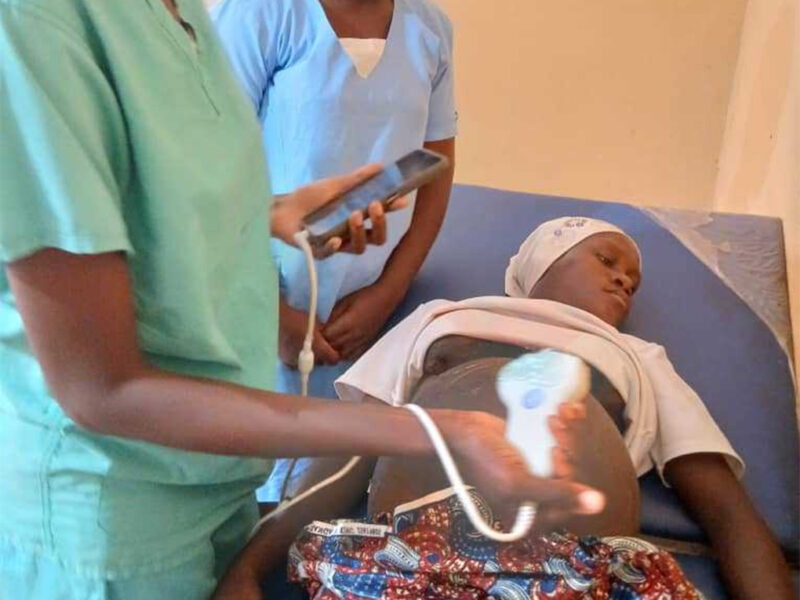 A health worker performing an obstetric ultrasound scan with BabyChecker on a pregnant woman in Yele, Sierra Leone.